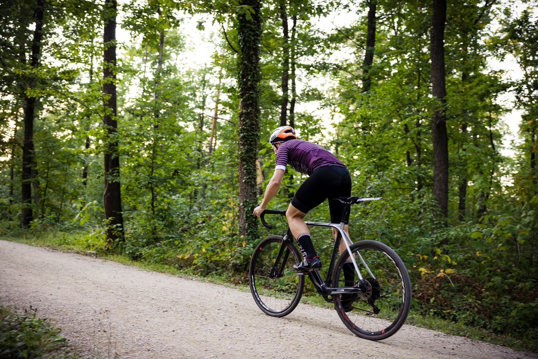 a person riding a road bike on a gravel road